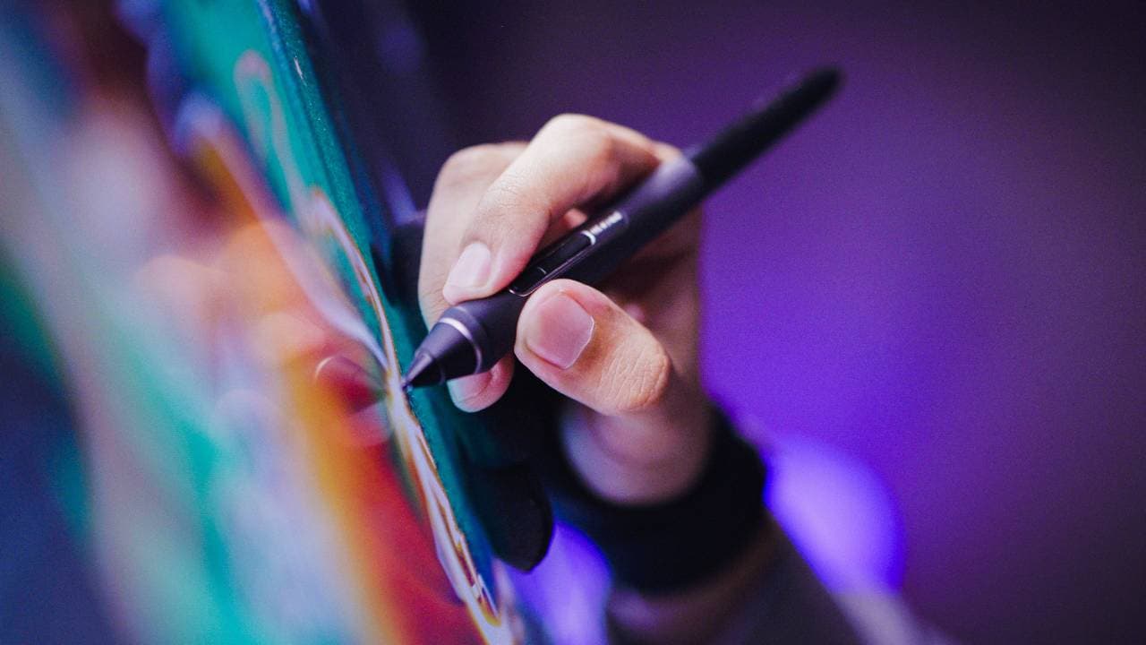 Close-up of hands typing on a smartphone with a glowing purple and teal light in the background