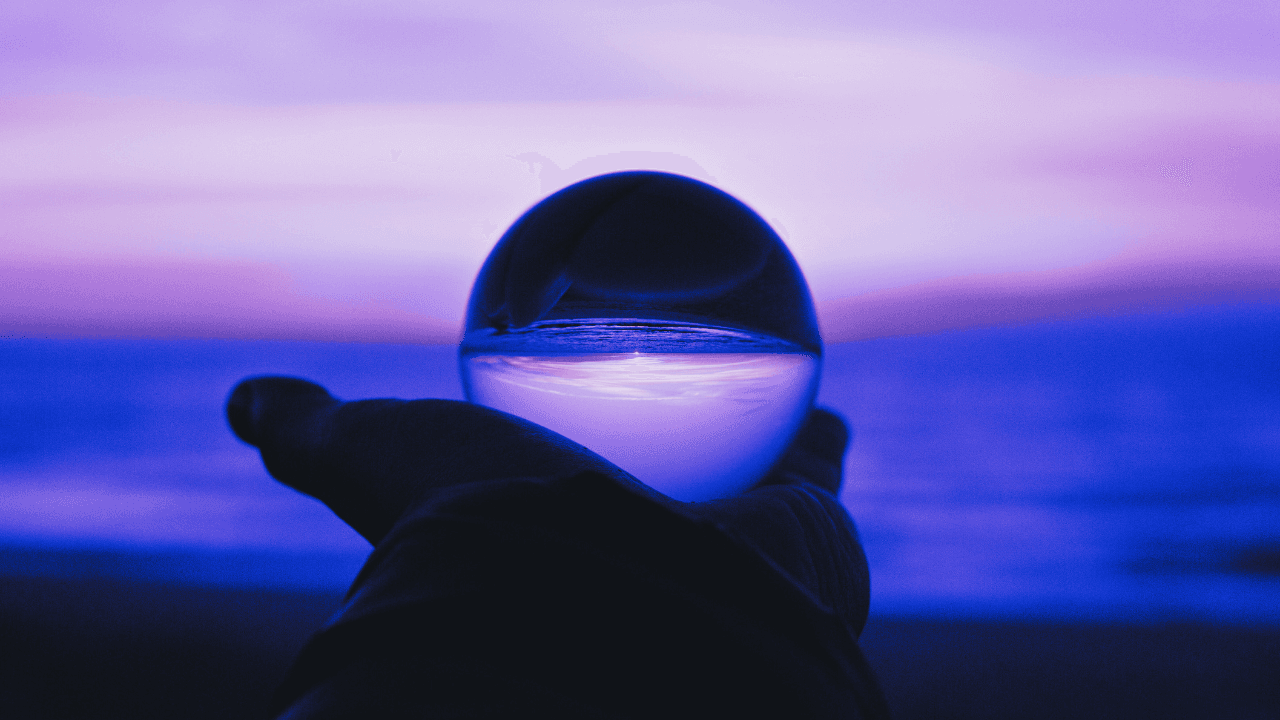 A glass sphere reflecting a purple and blue sunset sky, symbolising clarity and distinctiveness